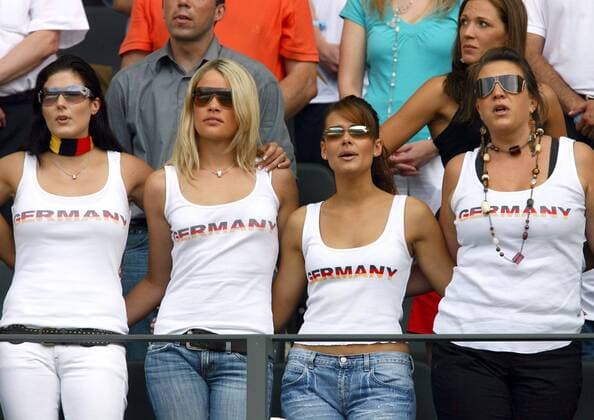 Die deutschen Spielerfrauen Arm in Arm während der Nationalhymne, v.li.: Petra Frings, Ehefrau von Torsten Frings, Lena (Tim Borowski) mit Chanel Sonnenbrille, Nicola (Philipp Lahm) und Inga (Thomas Hitzlsperger) Fußball WM Herren WM 2006, Länderspiel, Nationalteam, Gruppe A, Gast, Gäste, Besucher, Publikum Gruppe Berlin Tribüne Kameradschaft Fußball WM Herren WM 2006, Länderspiel, Nationalteam, Gruppe A, Gast, Gäste, Besucher, Publikum Gruppe Berlin Tribüne Kameradschaft