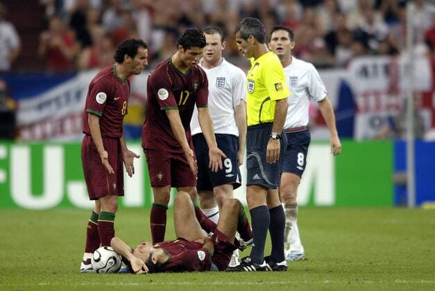 Ricardo Carvalho (Portugal) hält sich nach der Hochzeitsgrätsche von Wayne Rooney (Mitte) die Weichteile, während Lampard (beide England) sowie Petit (li.) und Cristiano Ronaldo (beide Portugal) von FIFA Schiedsrichter Horacio Elizondo (Argentinien)... Fußball Länderspiel Herren WM 2006, Nationalteam, Nationaltrikot, Viertelfinale, reklamieren, beschweren, meckern Streit Gruppe Schmerz, Verletzung Turnierhighlight Boden Gelsenkirchen streiten, Auseinandersetzung, Spannung Fußball Länderspiel Herren WM 2006, Nationalteam, Nationaltrikot, Viertelfinale, reklamieren, beschweren, meckern Streit Gruppe Schmerz, Verletzung Turnierhighlight Boden Gelsenkirchen streiten, Auseinandersetzung, Spannung