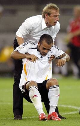 Bundestrainer Jürgen Klinsmann hilft David Odonkor (beide Deutschland) nach dem Ausscheiden im Halbfinale auf die Füße Fußball WM Herren WM 2006, Länderspiel, Nationalteam, Halbfinale, Nationaltrikot Gruppe Dortmund Enttäuschung, Fußball WM Herren WM 2006, Länderspiel, Nationalteam, Halbfinale, Nationaltrikot Gruppe Dortmund Enttäuschung,