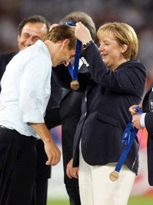 Bundeskanzlerin Angela Merkel (CDU) verleiht Bundestrainer Jürgen Klinsmann (beide Deutschland) eine Medaille nach dem Erfolg im Spiel um Platz 3 Fußball WM Herren WM 2006, Länderspiel, Nationalteam, Spiel um Platz 3, drei Gruppe Kanzler, Kanzlerin, Bundeskanzler, Stuttgart Freude, Fußball WM Herren WM 2006, Länderspiel, Nationalteam, Spiel um Platz 3, drei Gruppe Kanzler, Kanzlerin, Bundeskanzler, Stuttgart Freude,