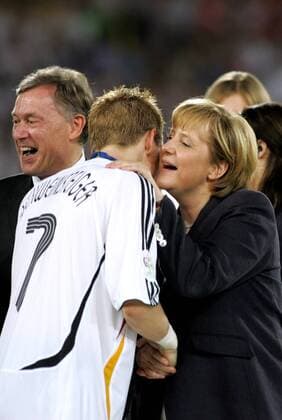 Bundeskanzlerin Angela Merkel (CDU) flüstert Bastian Schweinsteiger (Mitte) ihre Glückwünsche ins Ohr, li. Bundespräsident Horst Köhler (CDU alle Deutschland) - Fußball WM Herren WM 2006, Länderspiel, Nationalteam, Spiel um Platz 3, drei, Nationaltrikot, lachen, lächeln Gruppe Stuttgart Fußball WM Herren WM 2006, Länderspiel, Nationalteam, Spiel um Platz 3, drei, Nationaltrikot, lachen, lächeln Gruppe Stuttgart