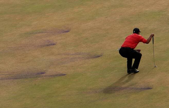 Eldrick Tiger Woods (USA) taxiert die Putlinie auf dem 18. und letzten Grün, wo mit Farbbeuteln in klassischem lila der neue British Open Gewinner bereits vorab geehrt wird -  (LON2006072328) Golf Herren British Open Championship 2006, PGA European Tour Totale Hoylake Liverpool Golf Herren British Open Championship 2006, PGA European Tour Totale Hoylake Liverpool