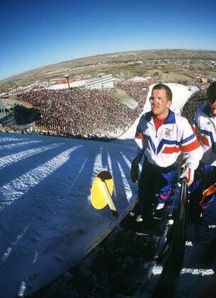 Eddy the Eagle Michael Edwards (Großbritannien) während der Olympischen Winterspiele 1988 in Calgary unter herrlich blauem Himmel auf dem Weg zur Schanze -  Skispringen OS Winter Herren Olympische Spiele 1988, Winterspiele, Nordischer Skisport, Ski Nordisch Einzelbild Calgary Weite, Skispringen OS Winter Herren Olympische Spiele 1988, Winterspiele, Nordischer Skisport, Ski Nordisch Einzelbild Calgary Weite,