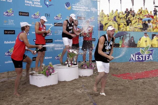 Europameister Julius Brink (Deutschland, re.) steigt bei der Siegerehrung des Nestea European Championship Final 2006 vom Podium und zelebriert den Sieg mit einer Sektdusche - die anderen Platzierten tun es ihm gleich Beachvolleyball EM Herren Nestea European Championship Final 2006, Finale, Tour, Beach, Gruppe Den Haag Begeisterung, Freude, Beachvolleyball EM Herren Nestea European Championship Final 2006, Finale, Tour, Beach, Gruppe Den Haag Begeisterung, Freude,