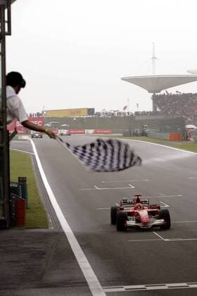 GP von China: Sieger Michael Schumacher (Deutschland Ferrari) Überquert die Ziellinie und wird abgewunken Motorsport Grand Prix Herren Großer Preis von China 2006, Formel 1 Weltmeisterschaft, F1, F, GP, WM Totale Shanghai Motorsport Grand Prix Herren Großer Preis von China 2006, Formel 1 Weltmeisterschaft, F1, F, GP, WM Totale Shanghai