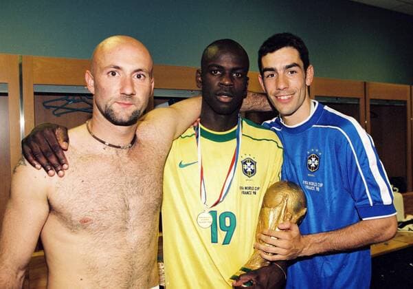 Weltmeister Frankreich, v.li.: Torwart Fabien Barthez, Lilian Thuram mit dem FIFA Weltpokal und Robert Pires, beide im Trikot von Brasilien -  (pan1359) Fußball Länderspiel Herren Weltmeisterschaft 1998, Nationalmannschaft, Nationaltrikot, Finale, Endspiel Gruppe Kabine, Kabinenfeier, Feier, feiern Paris, St. Denis, Saint Freude, Fußball Länderspiel Herren Weltmeisterschaft 1998, Nationalmannschaft, Nationaltrikot, Finale, Endspiel Gruppe Kabine, Kabinenfeier, Feier, feiern Paris, St. Denis, Saint Freude,  