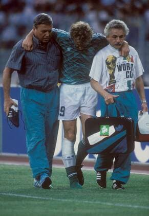 Mannschaftsarzt Prof. Dr. Heinrich Heß (li.) und Physiotherapeut Adolf Katzenmaier (re.) geleiten den verletzten Rudi Völler (alle BR Deutschland) vom Feld Fußball Länderspiel Herren WM 1990, Nationalmannschaft, Nationaltrikot, Halbfinale, BRD Gruppe Turin Enttäuschung, Nachdenklichkeit, Fußball Länderspiel Herren WM 1990, Nationalmannschaft, Nationaltrikot, Halbfinale, BRD Gruppe Turin Enttäuschung, Nachdenklichkeit,