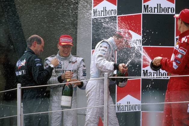 Siegerehrung GP Spanien 1999: David Coulthard (Schottland, 2.v.re.) bekommt von Michael Schumacher (Deutschland Ferrari, re.) eine Sektdusche, Sieger Mika Häkkinen (Finnland, 2.v.li.) mit Technikdirektor Adrian Newey (England beide McLaren Mercedes) Motorsport Grand Prix Herren Großer Preis von Spanien 1999, Formel 1 Weltmeisterschaft, F1, F, GP, WM Gruppe Circuit de Catalunya Barcelona Freude, Motorsport Grand Prix Herren Großer Preis von Spanien 1999, Formel 1 Weltmeisterschaft, F1, F, GP, WM Gruppe Circuit de Catalunya Barcelona Freude,