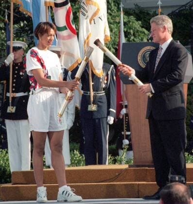 Präsident Bill Clinton übergibt Carla McGhee (beide USA) das olympische Feuer für den weiteren Fackellauf anlässlich der Sommerspiele 1996 in Atlanta -  (WAP96062101) Basketball OS Sommer Damen Vorschau Olympische Spiele Atlanta 1996, Sommerspiele, Nationalteam Gruppe o0 Fackelläuferin Washington DC, D C Basketball OS Sommer Damen Vorschau Olympische Spiele Atlanta 1996, Sommerspiele, Nationalteam Gruppe o0 Fackelläuferin Washington DC, D C