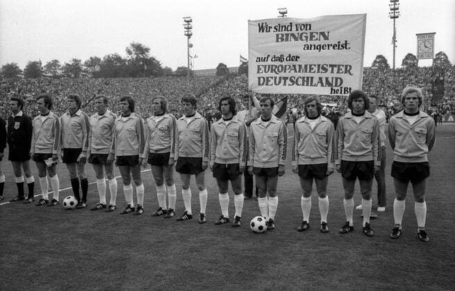 Hymne BR Deutschland v.li.: Franz Beckenbauer, Torwart Sepp Maier, Hans Georg Schwarzenbeck, Jupp Heynckes, Günter Netzer, Herbert Wimmer, Gerd Müller, Horst Dieter Höttges, Erwin Kremers, Paul Breitner und Uli Hoeneß; dahinter ein Fanplakat: ... Fußball Länderspiel Herren EM 1972, Nationalmannschaft, BRD, Finale Endspiel Vorstellung Mannschaftsvorstellung Vneg Vsw Totale Brüssel Fußball Länderspiel Herren EM 1972, Nationalmannschaft, BRD, Finale Endspiel Vorstellung Mannschaftsvorstellung Vneg Vsw Totale Brüssel