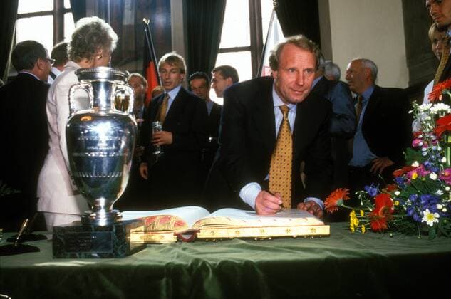 Bundestrainer Berti Vogts (Deutschland) trägt sich neben dem Coupe Henri Delaunay während des Rathausempfangs in das Goldene Buch der Stadt Frankfurt ein Fußball Herren EM 1996 Nationalmannschaft, Empfang Ankunft Rathaus Rathausempfang Europameister unterschreiben Vdia Einzelbild Frankfurter Römer Römerberg Frankfurt M. goldenes Unterschrift schreiben Fußball Herren EM 1996 Nationalmannschaft, Empfang Ankunft Rathaus Rathausempfang Europameister unterschreiben Vdia Einzelbild Frankfurter Römer Römerberg Frankfurt M. goldenes Unterschrift schreiben