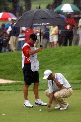 Eldrick Tiger Woods (USA) taxiert die Ideallinie, während ihn Caddie Steve Williams (Neuseeland) mit einem Regenschirm schützt -  (WAP20070705332) Golf Herren AT&T National 2007, PGA Tour, AT & T Gruppe Bethesda Golf Herren AT&T National 2007, PGA Tour, AT & T Gruppe Bethesda