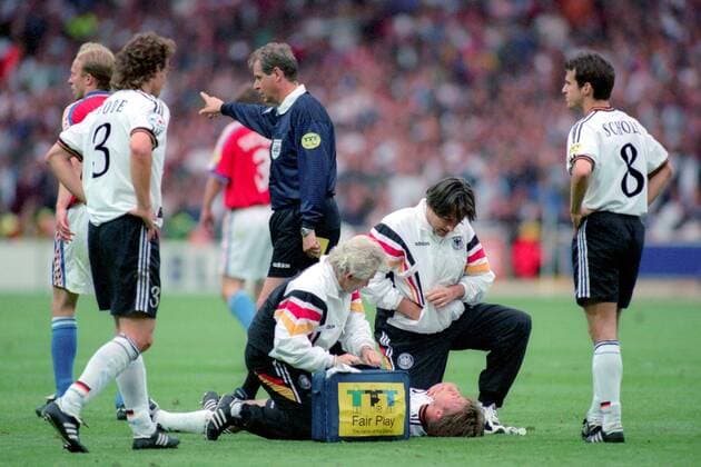 Fußball, EM Finale 1996 in London, Deutschland - Tschechien 2:1 n.V. Mannschaftsarzt Dr. Hans Wilhelm Müller Wohlfahrt (2.v.re.) und Masseur Adolf Katzenmaier (4.v.li.) behandeln Thomas Helmer (Mitte), daneben Mehmet Scholl (re.), Marco Bode (alle Deutschland, 2.v.li.) und FIFA Schiedsrichter Pierluigi Pairetto (Italien) Fußball Länderspiel Herren EM 1996, Nationalmannschaft, Nationaltrikot, Finale, Endspiel, Deutschland - Tschechien 2:1 n.V. Gruppe London Fußball Länderspiel Herren EM 1996, Nationalmannschaft, Nationaltrikot, Finale, Endspiel, Deutschland - Tschechien 2:1 n.V. Gruppe London