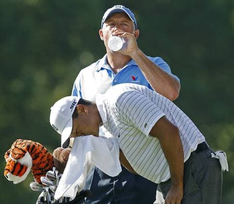 Eldrick Tiger Woods (USA, vorn) wischt sich den Schweiß vom Gesicht, während sich sein Caddie Steve Williams (Neuseeland) einen Schluck Wasser gönnt -  (TUL2007080901) Golf Herren 89. PGA Championship 2007, Tour, Gruppe Southern Hills Country Club Tulsa Golf Herren 89. PGA Championship 2007, Tour, Gruppe Southern Hills Country Club Tulsa