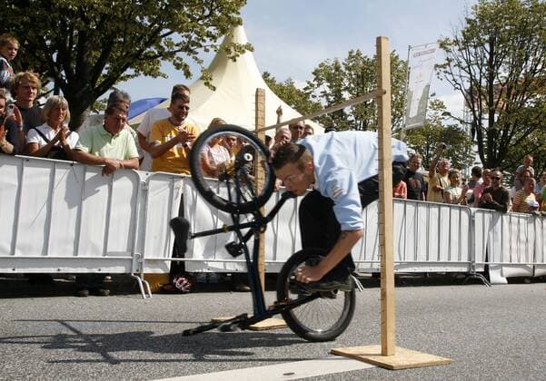 BMX Fahrer zeigt im Showprogramm der Vattenfall Cyclassics 2007 einen spektakulären Stunt und fährt mit seinem BMX Rad gebückt unter einer Hürde hindurch Radsport Herren Vattenfall Cyclassics 2007, Straßenradsport, Straße, Rad, Einzelbild Hamburg Radsport Herren Vattenfall Cyclassics 2007, Straßenradsport, Straße, Rad, Einzelbild Hamburg