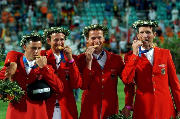 Siegerehrung der Teamwertung bei den Olympischen Sommerspielen 2004, v.li.: Die Olympiasieger Ludger Beerbaum, Christian Ahlmann, Marco Kutscher und Otto Becker (alle Deutschland) beißen in die Medaillen Pferdesport OS Sommer Herren Olympische Sommerspiele Athen 2004, Olympiade, Olympia, Spiele, Reiten, Reitsport Gruppe Jubel, Siegesjubel, Biss, beißen, prüfen Markopoulo o0 Aufmacher Freude, Pferdesport OS Sommer Herren Olympische Sommerspiele Athen 2004, Olympiade, Olympia, Spiele, Reiten, Reitsport Gruppe Jubel, Siegesjubel, Biss, beißen, prüfen Markopoulo o0 Aufmacher Freude,