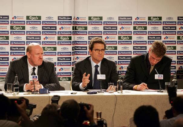 Der neue Nationaltrainer Fabio Capello (Mitte) zwischen seinem Übersetzer (re.) und FA Geschäftsführer Brian Barwick (alle England) während der Pressekonferenz - EDITORIAL USE ONLY. No use with unauthorised audio, video, data, fixture lists, club league logos or live services. Online in-match use limited to 120 images, no video emulation. No use in betting, games or single club league player publications. Herren Nationalteam 2007, Pressekonferenz, Pressetermin, Präsentation, Vorstellung Gruppe Schriftzug, Mikro, Mikrofon, London Herren Nationalteam 2007, Pressekonferenz, Pressetermin, Präsentation, Vorstellung Gruppe Schriftzug, Mikro, Mikrofon, London