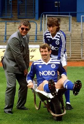 Fußball, Trainerhistorie Brighton & Hove Albion von 1901 bis heute Trainer Alan Mullery (li.) und Dale Jasper (re.) mit Gerry Armstrong (alle Brighton) in der Schubkarre -  Fußball Herren English Football League Second Division 1986 1987, Two, 2. Englische Liga Gruppe Brighton Komik, Fußball Herren English Football League Second Division 1986 1987, Two, 2. Englische Liga Gruppe Brighton Komik,
