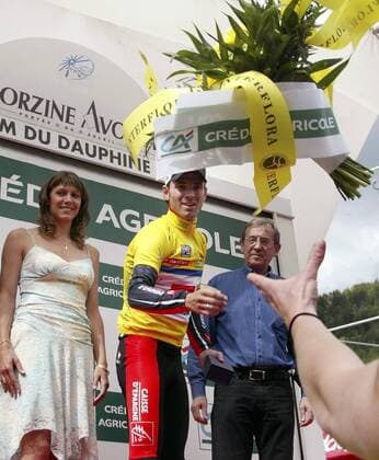 Alejandro Valverde (Spanien Caisse d Epargne), im gelben Trikot, wirft einen Blumenstrauß vom Podium bei der Siegerehrung zur 5. Etappe des Criterium du Dauphine Libere 2008 Radsport Herren Criterium du Dauphine Libere 2008, ProTour, Straßenradsport, Straße, Rad Gruppe 5. Etappe: Ville La Grand - Morzine Freude,
