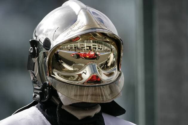 Ferrari Bolide spiegelt sich im Visier des Helms eines Feuerwehrmanns Motorsport Grand Prix Herren Großer Preis von Frankreich 2008, Formel 1 Weltmeisterschaft, F1, F, GP, WM, Training Einzelbild Magny Cours