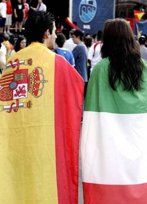 Fußballfans aus Spanien (li.) und Italien warten, eingehüllt in die Landesfahne, auf das Euro 2008 Viertelfinalspiel ihrer beiden Nationalteams -  Fußball EM Herren Euro 2008, Länderspiel, Viertelfinale, Nationalteam Gruppe Basel