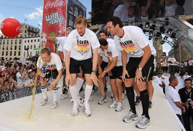 Abschlussfest der EURO 2008 auf der Berliner Fanmeile - ARD Moderator Oliver Pocher (li.) bekommt eine Bierdusche von Bastian Schweinsteiger, vorn: Christoph Metzelder (re.) und Per Mertesacker (alle Deutschland) Fußball EM Herren EURO 2008, Nationalmannschaft, Fanmeile, Fanfest, Fest, Feier, Party, Empfang Gruppe Berlin Freude,