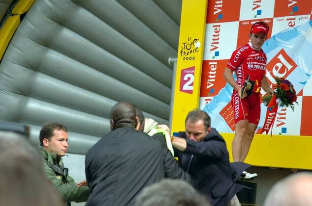 Demonstrant, der während der Siegerehrung von Etappensieger Samuel Dumoulin (Cofidis) auf den Stellenabbau in der Region aufmerksam macht, wird von Sicherheitskräften und Bernard Hinault (beide Frankreich, 2.v.re.) abgeführt -  Radsport Herren Tour de France 2008, Straßenradsport, Straße, Rad Gruppe 3. Etappe: St. Malo - Nantes Kampf, Spannung,