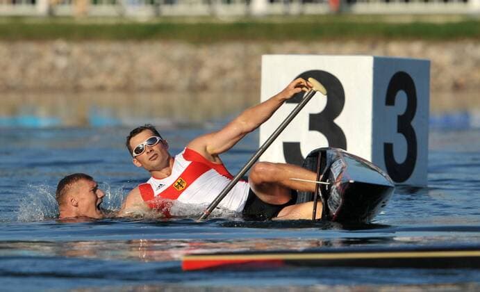 Tomasz Wylenzek hat nach dem Finalrennen einen Kreislaufkollaps und fällt völlig erschöpft ins Wasser, li. Christian Gille (beide Deutschland) - sie werden Zweiter im 1000m Zweiercanadier bei den olympischen Spielen 2008 Kanu OS Sommer Herren Olympische Sommerspiele Peking 2008, Spiele, Nationaltrikot Gruppe Peking Shunyi Erschöpfung