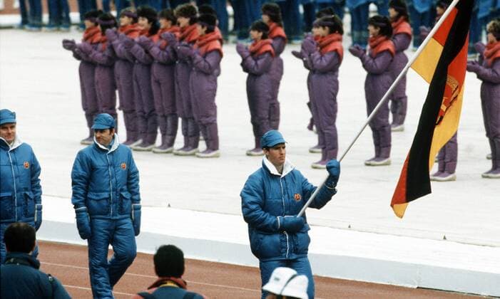 Fahnenträger Frank Ullrich gefolgt von DTSB Vizepräsident Dr. Thomas Köhler (Mitte) und DTSB Präsident Manfred Ewald (alle DDR) während der Eröffnungsfeier der Olympischen Winterspiele 1984 in Sarajevo Biathlon OS Winter Herren Olympische Spiele 1984, Winterspiele, Eröffnung, Zeremonie, Eröffnungszeremonie, Gruppe Sarajevo