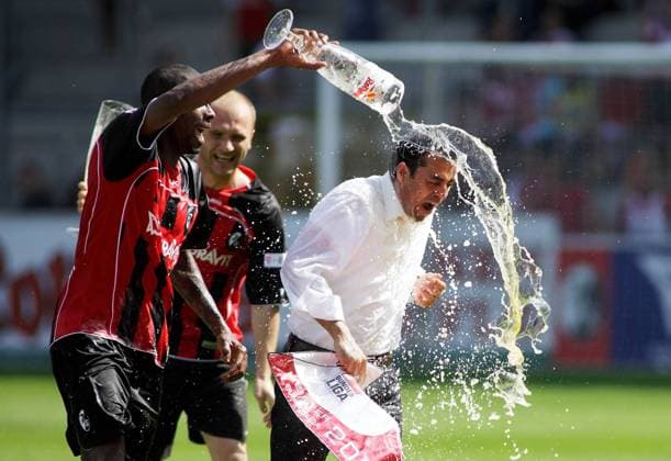 Mohamadou Idrissou (li.) verpasst Trainer Robin Dutt (beide Freiburg) die obligatorische Bierdusche Fußball 2. BL Herren Saison 2008 2009, SC Freiburg Gruppe Freiburg Begeisterung, Freude,