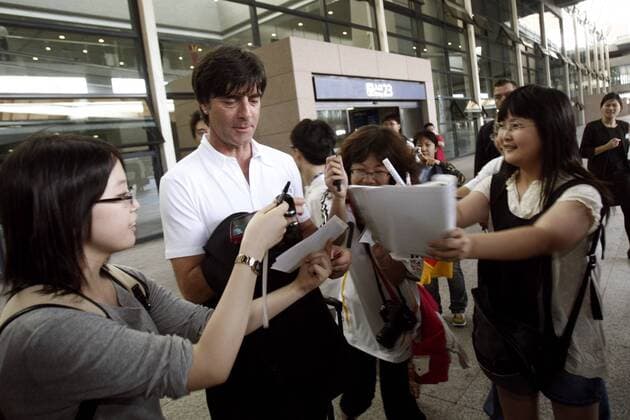 Bundestrainer Joachim Löw (Deutschland) wird nach seiner Ankunft auf dem Flughafen in Shanghai von Autogrammjägern belagert -  (CFP399293242) Fußball Herren Nationalmannschaft 2009, o0 Asienreise Gruppe Shanghai