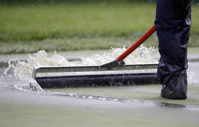 Regenpause bei den US Open 2009 - Ein Greenkeeper versucht mit einer Walze das Wasser zu entfernen -  (NYP20090618122) Golf Herren US Open 2009, PGA Tour Einzelbild Farmingdale Bethpage