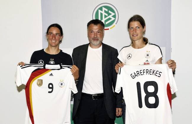 Birgit Prinz (li.) und Kerstin Garefrekes präsentieren auf einer Pressekonferenz das neue Heimtrikot, dazwischen Fotograf Horst Hamann (alle Deutschland) Fußball Damen Nationalmannschaft 2009, Pressekonferenz, Pressetermin, Frauen, Frauenfußball Gruppe Sinsheim