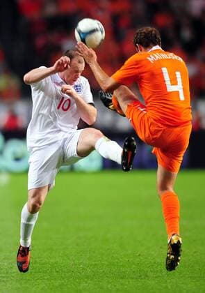 Wayne Rooney (L) of England shows commitment going in on Joris Mathijsen of Holland EDITORIAL USE ONLY. No use with unauthorised audio, video, data, fixture lists, club league logos or live services. Online in-match use limited to 120 images, no video emulation. No use in betting, games or single club league player publications.