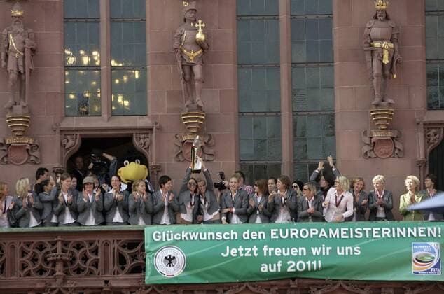 Spielerinnen auf dem Rathausbalkon beim Empfang der Frauenfußball Nationalmannschaft am Frankfurter Römer nach dem Gewinn der Europameisterschaft . Unter ihnen ein DFB Plakat mit einem Glückwunsch und einem Hinweis auf die WM 2011 o00 sieg