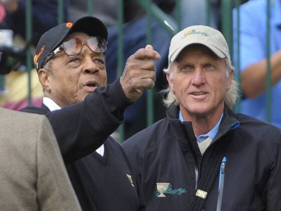 Baseball legend Willie Mays (L) flips the opening coin as International team captain Greg Norman watches during the second round of The Presidents Cup at Harding Park Golf Course in San Francisco, California on October 9, 2009.  SFP20091009367 o00 The President s