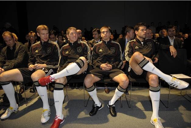 WM 2010 Adidas Trikotvorstellung: Warten in der ersten Reihe auf ihren Einsatz, v.li: Per Mertesacker (Deutschland), Bastian Schweinsteiger (Deutschland), Philipp Lahm (Deutschland), Michael Ballack (Deutschland).