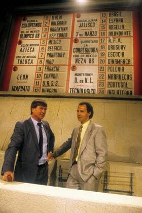 Nationaltrainer Sepp Piontek (Dänemark, li.) und Teamchef Franz Beckenbauer (BR Deutschland) unterhalb des Spielplans der WM 1986 Fußball WM Herren Auslosung Auslosung 1985 WM 1986, Gruppenauslosung Gruppe