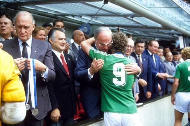 Bundeskanzler Helmut Kohl (CDU) gratuliert Rudi Völler (beide BR Deutschland) nach dem Finale der WM 1986 zur Vizeweltmeisterschaft, li. FIFA Präsident Joao Havelange (Brasilien); 2.v.li.: Präsident Miguel de la Madrid Hurtado (Mexiko) Fußball WM Herren WM Finale 1986, Länderspiel, Nationalteam, Nationaltrikot Gruppe Mexiko City
