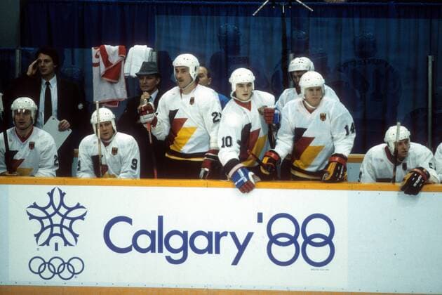 Ersatzbank BR Deutschland mit Bundestrainer Xaver Unsinn (4. v. li.) und Dieter Hegen (5. v. li.) Eishockey OS Winter Herren Olympische Spiele Calgary 1988, Winterspiele, Länderspiel, Nationalteam, Nationaltrikot, Gruppe Calgary