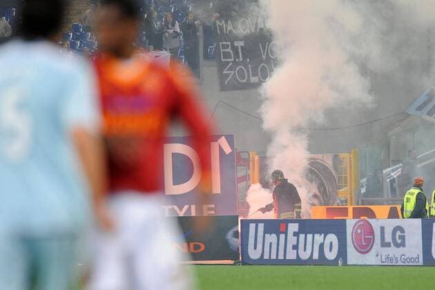 Feuerwehrmann entfernt eine Rauchbombe, die während des Derbys zwischen AS und Lazio Rom geworfen wurde  o0 Sicherheit, Stadionsicherheit, bengalisches Feuer, Bengalfeuer, Wurfgeschoss, Derby