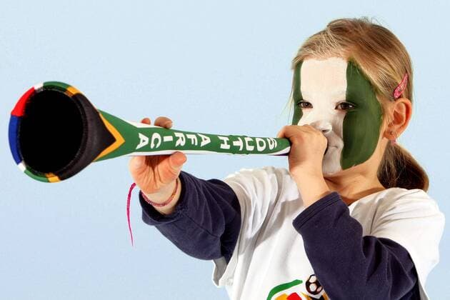 Kind mit Gesichtsbemalung in den Landesfarben des WM Teilnehmers Nigeria (Gruppe B) bläst in eine Vuvuzela - FUSSBALL - FIFA WM 2010, Fotoshooting mit Kindern - MODEL RELEASED  o00 Tröte Fantröte