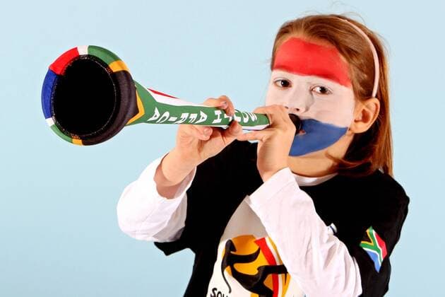 Kind mit Gesichtsbemalung in den Landesfarben des WM Teilnehmers Niederlande (Gruppe E) bläst in eine Vuvuzela - FUSSBALL - FIFA WM 2010, Fotoshooting mit Kindern - MODEL RELEASED.  o00 Tröte Fantröte