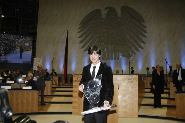Preisträger Joachim LÖW (GER), präsentiert seinen Preis, hi. der Bundesadler, Verleihung des Zukunftspreises 2009 durch die Initiative Forum Zukunft e.V. an Fussball-Bundestrainer Joachim LOEW, Zukunftspreis 2009, Verleihung im World Conference Center Bonn, 28.01.2010, o0 Nationaltrainer Trainer Objekte Pokal Trophäe o00 Politik Plenarsaal Bundestag
