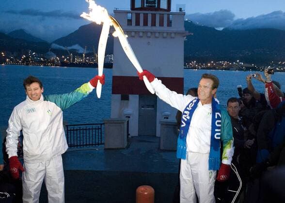 Feb. 12, 2010 - Vancouver, British Columbia, Canada - OLYMPIC TORCH - Governor Arnold Schwarzenegger (USA, R) hands off the Olympic torch to Vicepresident Sebastian Coe (GBR) on Friday morning, the day of the opening ceremony at the Vancouver Games at Vancouver s Stanley Park Friday, February 12, 2010 as the flame makes its final pass through the city on its way to the Opening Ceremony of the 2010 Winter Olympics..The California governor and the two-time Olympic gold medalist runner were revealed Monday as torch relay participants along with several famous Canadians, including the father of hockey great Wayne Gretzky. The 106-day torch relay comes to an end this Friday after having covered more than 45,000 kilometres..Vancouver Olympics 2010 in Vancouver, British Columbia. - ZUMAj89