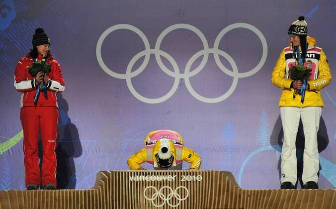 Gold medalist Germany s Tatjana Huefner (C) kisses the podium as silver medalist Austria s Nina Reithmayer (L) and bronze medalist Germany s Natalie Geisenberger watch during the women s luge singles victory ceremony during the 2010 Vancouver Winter Olympics, in Whistler, Canada, February 16, 2010.  OLY20100216366 o0 Sieg, Sieger, Olympiasieg, Olympiasieger, Jubel, Freude,