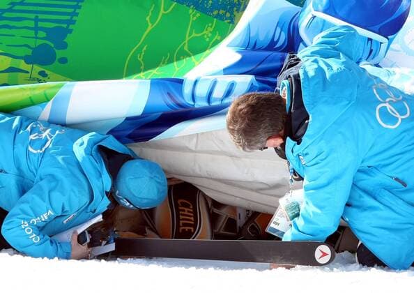 OLYMPIA - Olympische Winterspiele 2010 WHISTLER,KANADA,17.FEB.10 - DIVERS, OLYMPIA, SKI ALPIN - Olympische Winterspiele Vancouver 2010, Abfahrt der Damen. Noelle Barahona (CHI) ist im Ziel hinter die Bande gerutscht und wird von Helfern geborgen. Keywords: Sturz.  o0 kurios pessimistisch Sturz stürzen Pleiten Pech Pannen Mißgeschick Helfer