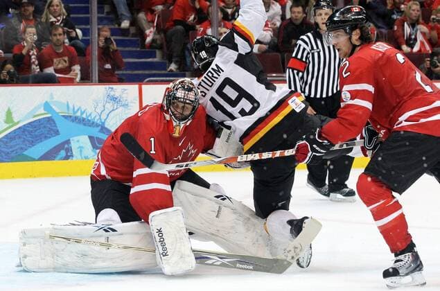 Canada s Roberto Luongo (L) battles against Germany s Marco Sturm (C) as Canada s Duncan Keith looks on during second period action in the men s hockey qualification play-offs at Canada Hockey Place in Vancouver, BC during the 2010 Winter Olympics, February 23, 2010. - ZUMAw51