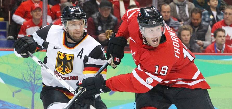Canada s Joe Thornton (R) battles against Germany s Sven Felski in the men s hockey qualification play-offs at Canada Hockey Place in Vancouver, BC during the 2010 Winter Olympics, February 23, 2010. - ZUMAw51