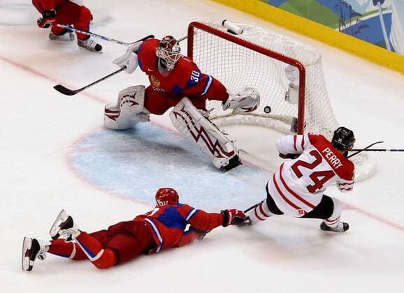 Vancouver , 240210 , Olympische Spiele Vancouver 2010 , Eishockey Play-Offs , Russland (Rot) - Kanada (Weiß) - Goalie Ilya Bryzgalov (Russland) gegen Corey Perry (Kanada)